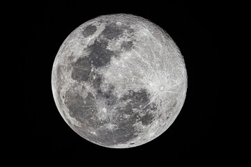 Full moon showing detailed craters and lunar surface textures against a black night sky. © wannasak