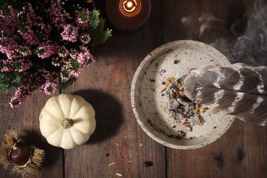 Samhain incense ritual &ndash; spreading sacred smoke with a feather