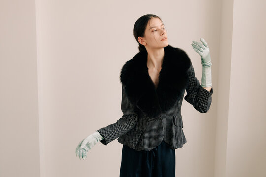 Elegant editorial portrait with expressive gesture and satin gloves