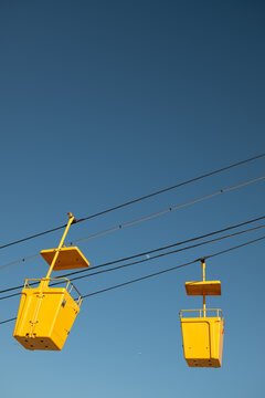 Yellow Cable Cars Move Along Lines in Clear Sky