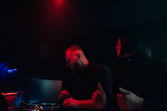 DJ Performs in a Club With Red Lighting During a Late Night Event