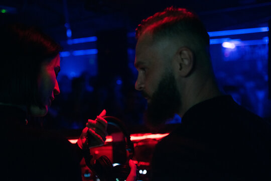DJ giving headphones to colleague