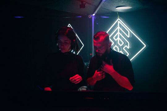Focused DJs playing at night club