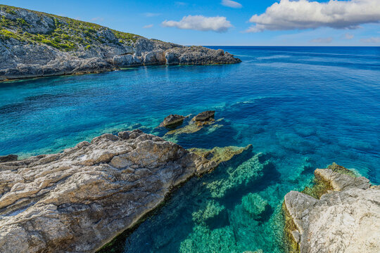 Spectacular Greek rocky coast deep blue turquoise sea rugged limestone cliffs summer sunshine sky paradise. Peaceful summer travel scene nature. Scenic Mediterranean adventure shoreline background 