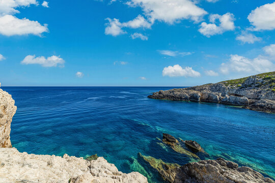 Breathtaking Greek clifftop deep blue sea rugged rocky coastline bright summer sky Mediterranean island view. Peaceful summer travel scene nature. Scenic dramatic coastal seascape summer wallpaper