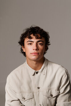 Young Man Poses for a Close-Up Shot Against a Simple Background