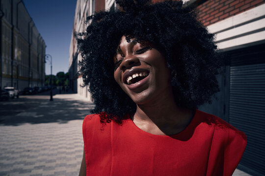Woman smiles on a city street on a sunny day