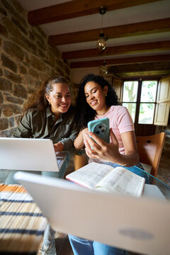Two women collaborating remote working from a home office