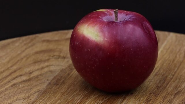 Rotating apple on wooden surface.