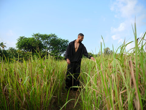 Man exploring tall grass in natural landscape