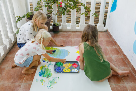 Kids finger paint with colored tempera on the terrace