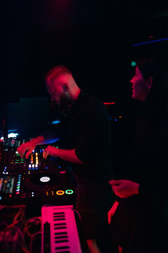 DJ Performs at a Live Music Event in a Dark Venue at Night