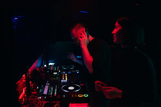 DJ playing music at nightclub and using headphones