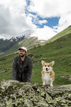 Man with Pembroke Welsh Corgi in Caucasus mountains