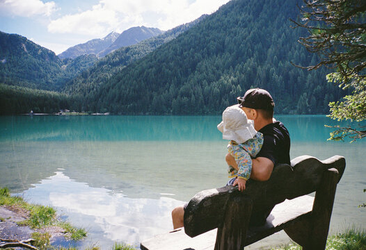Anonymous father and his little daughter relaxing near the lake