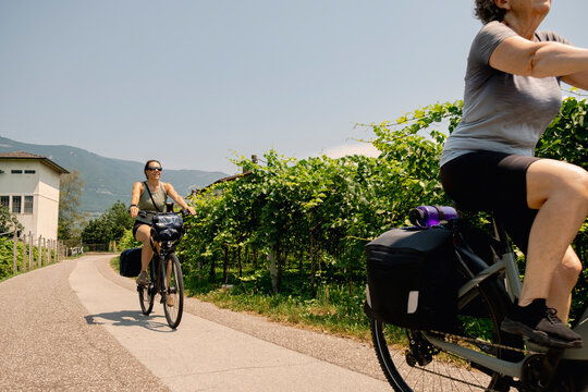 Multigeneration women cycling past vineyards in Italy