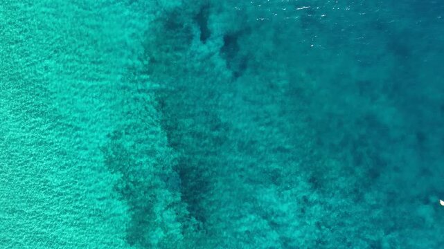 Aerial top-down view of the sea, then the camera tilts up to reveal the sky and horizon over the Mediterranean near Benidorm, Costa Blanca, Alicante, Spain, morning.