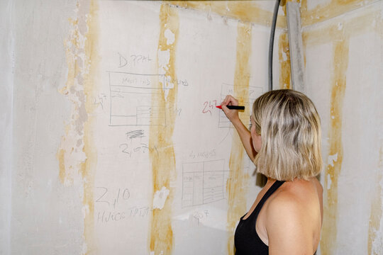 Anonymous Architect marking wall plans during home renovation