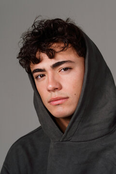 Young Man With Curly Hair Wearing a Hooded Sweatshirt