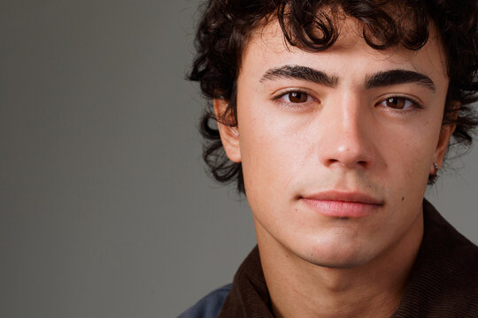 Close-up of a Young Man With Curly Hair and a Serious Expression