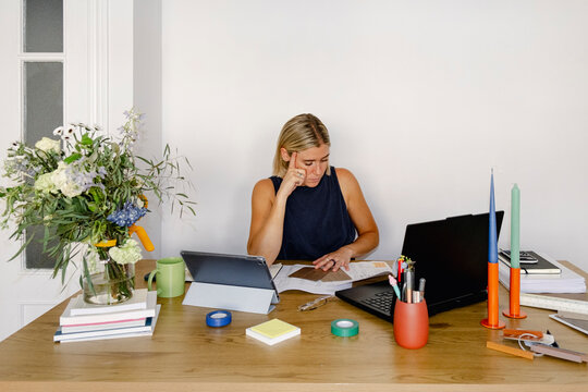 Woman architect reviewing floor plans in home office