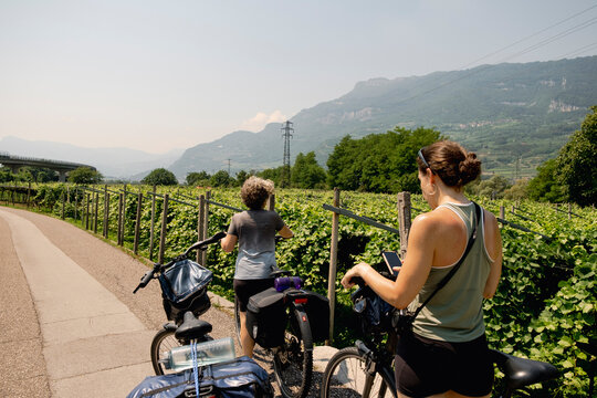 Mother and daughter pausing by vineyards on Italy bike trip