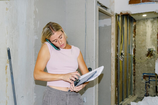 Architect coordinating renovation work by phone