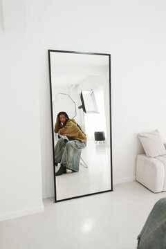 Model Posing in a Studio With a Large Mirror and Softbox Lights