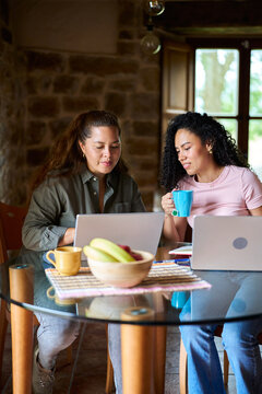 Women collaborating remotely, working from home with laptops