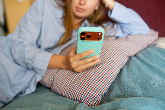 Anonymous woman using smartphone in bed
