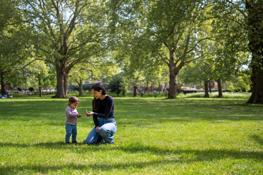 Mother Playing With Baby On Grass In London Park