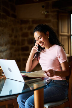 Woman working remotely from home office talking on phone