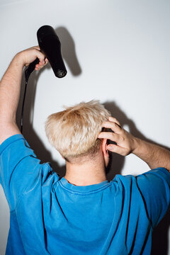 Young Man Blow Drying Bleached Hair from Behind