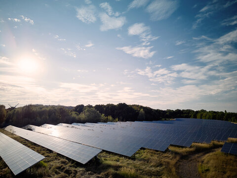 Solar Panels in a Field During the Day With Blue Sky and Clouds