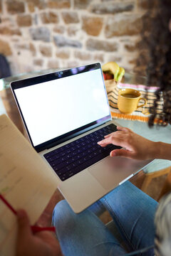Person typing on laptop, working remotely from home