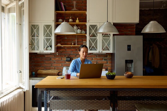Woman uses a laptop at home