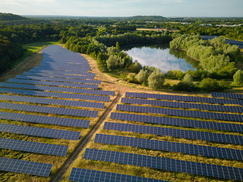 Solar Panels Cover Land Near a Lake in an Open Area