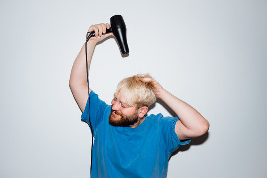 Young Man Blow Drying Bleached Hair at Home