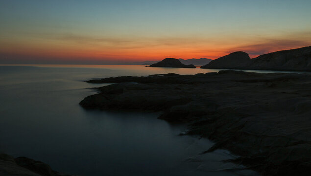 Quiet early pre dawn sunrise with colorful sky over Aegean Sea at Mandrakia village on Greek island Milos in Greece.