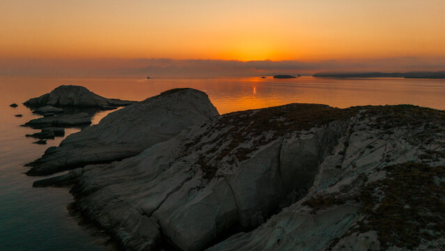 Quiet early pre dawn sunrise with colorful sky over Aegean Sea at Mandrakia village on Greek island Milos in Greece.