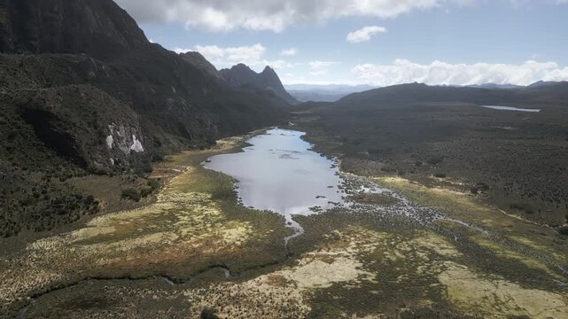 Aerial drone view of the high-altitude Sumapaz Paramo ecosystem in Colombia featuring native frailejon plants, glacial lakes, and rugged Andean mountains.