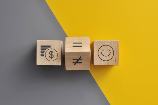 An image of money and a happy face, the concept being whether money equals or does not equal happiness.