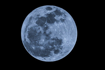 Blue moon glows softly against pitch black sky. Craters and maria visible in serene lunar surface. Ideal for astronomy, cosmic, or dreamy mood themes. No people, no animals, no plants present © Dian
