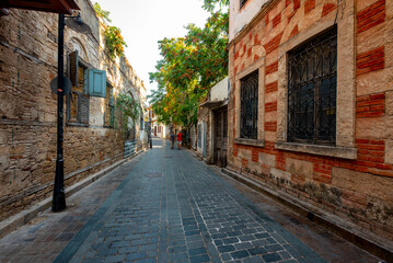 Obraz premium Antalya, Turkey - August 27, 2026: The image shows a historic cobblestone street in Kaleiçi, the old town of Antalya, Türkiye, featuring traditional Ottoman-style architecture and ancient stone. Histo