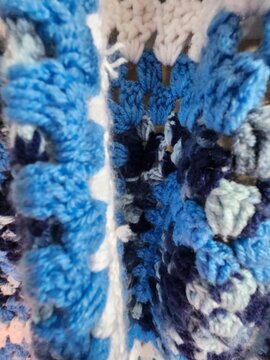 close up of knitting afhan handmade cozy winter fall snuggle ble white folded blanket