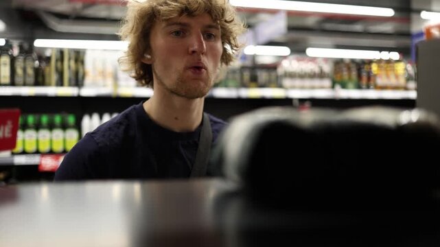 Shopper spots his favorite product on a supermarket shelf and reacts with excitement before reaching for the item showing recognition choice satisfaction and buying intent
