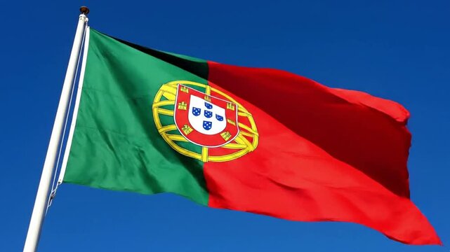 National flag of portugal waving against a clear blue sky
