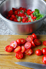 Fresh cherry tomatoes chopped on wooden cooking board. Organic food concept. Tomatoes in salad...