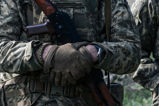 Ukrainian serviceman in digital camo with tactical gloves and a rifle
