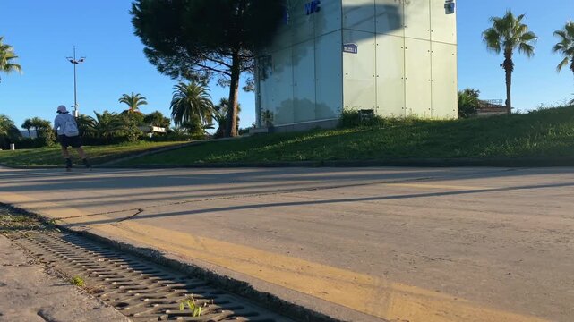 Woman rollerblading in low angle view along a paved waterfront path in Batumi on the Black Sea coast, suited for outdoor fitness, active travel, recreational sport, urban mobility, tourism promotion